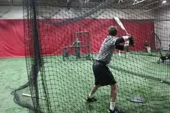 Student swinging his bat during a drill at Philadelphia Reds baseball training academy